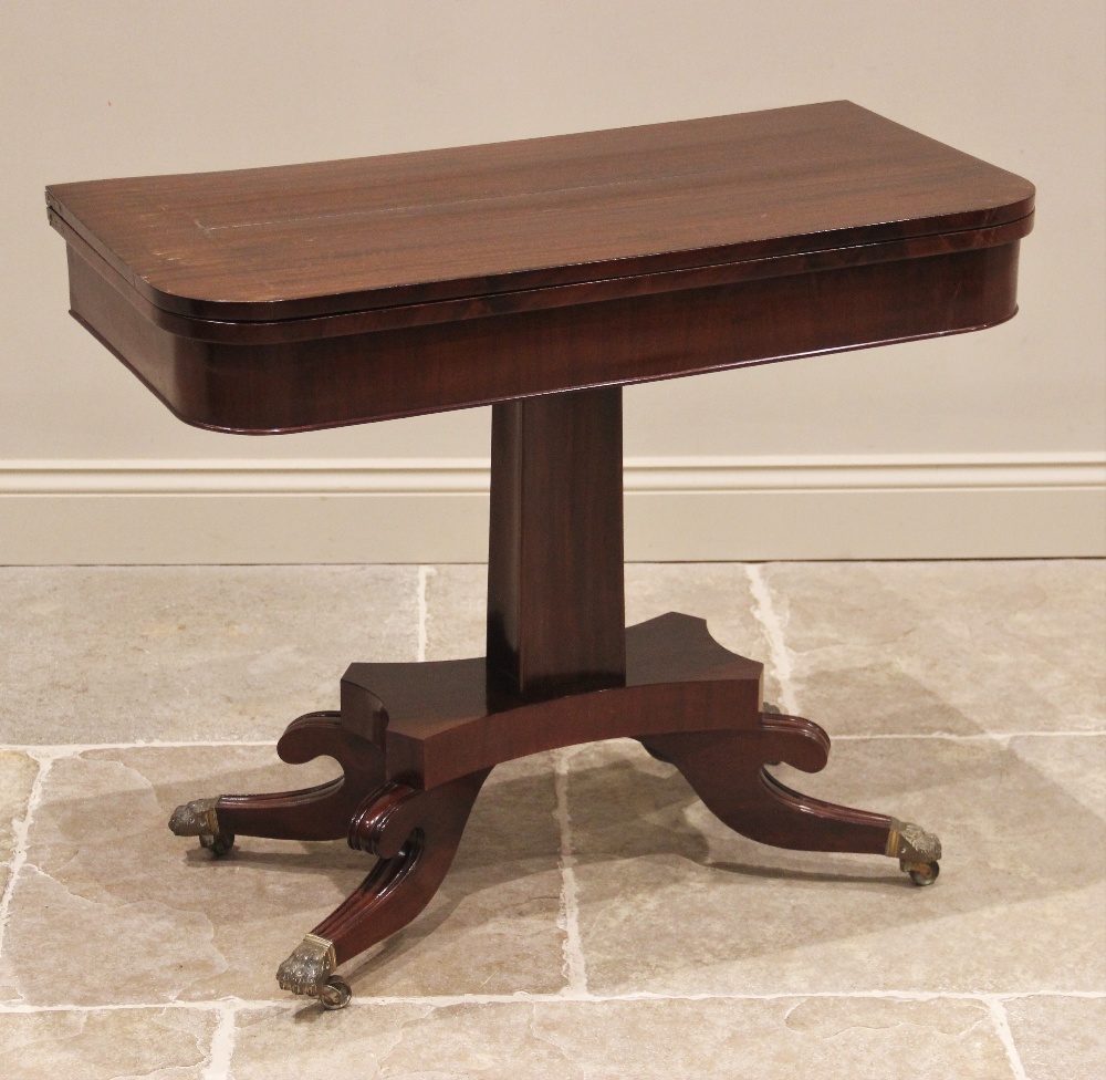 A George IV mahogany tea table, the quatreform pedestal raised upon four sabre supports, brass paw