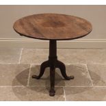 A George III oak tilt-top tripod table, the circular plank top raised upon a ring turned gun