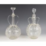 Two Dutch globe and shaft decanters, each with twin handles, the globes sectioned with prunted and