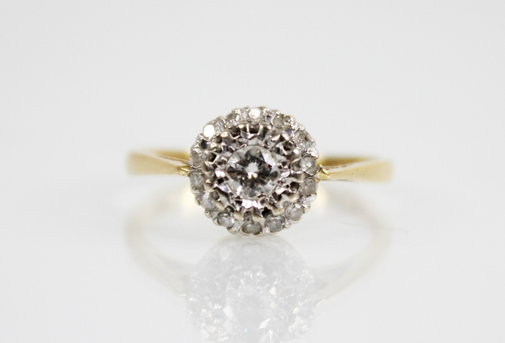 A diamond cluster 18ct gold ring, the central round brilliant cut diamond weighing approximately 0.