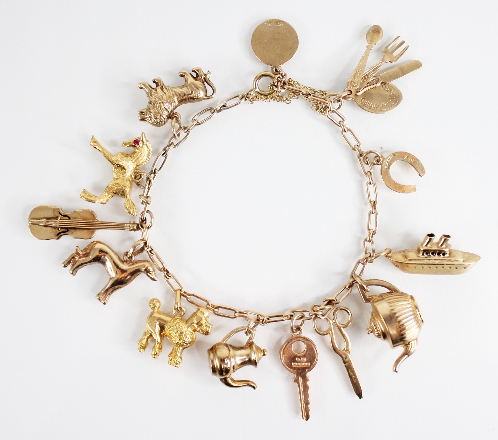 A gold coloured charm bracelet, the cable link bracelet with spring ring and loop fastening