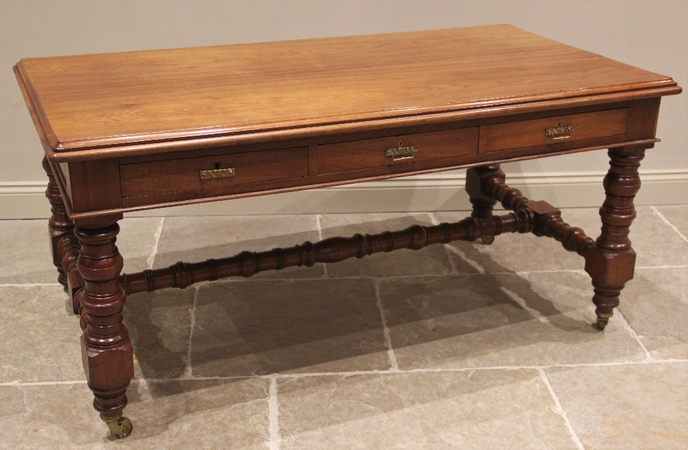 A late Victorian walnut library/writing table by Maple & Co, the rectangular thumb moulded top above