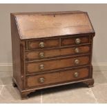 A George III oak and mahogany crossbanded bureau, the fall front centred with an inlaid cartouche
