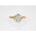 An early 20th century diamond floral cluster ring, designed as a central round brilliant cut diamond