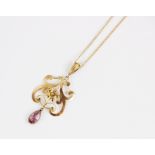 An early 20th century 9ct gold amethyst pendant, the openwork scrolling pendant with central