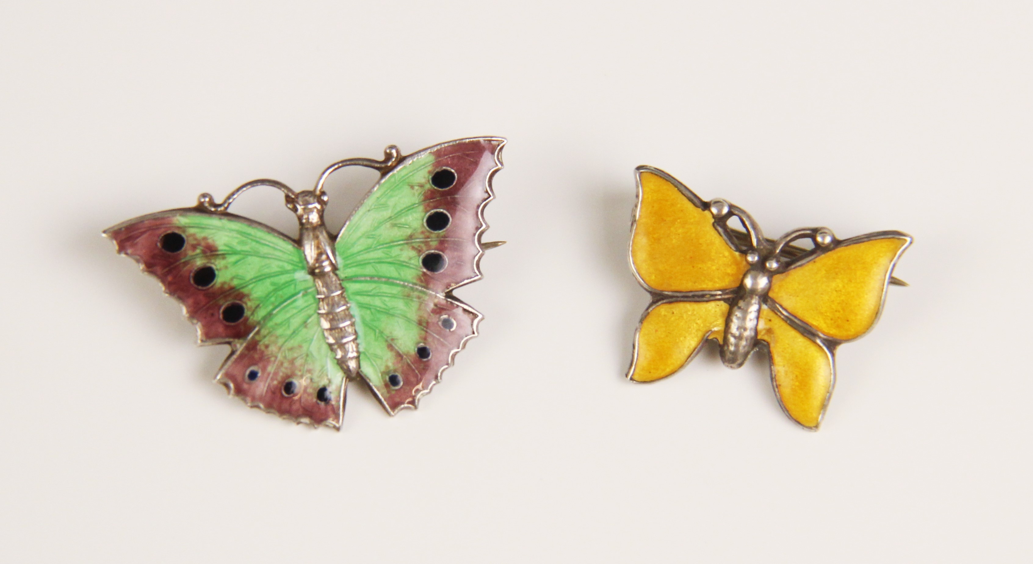 A silver and enamel butterfly brooch, the wings decorated in green, purple and blue enamel,