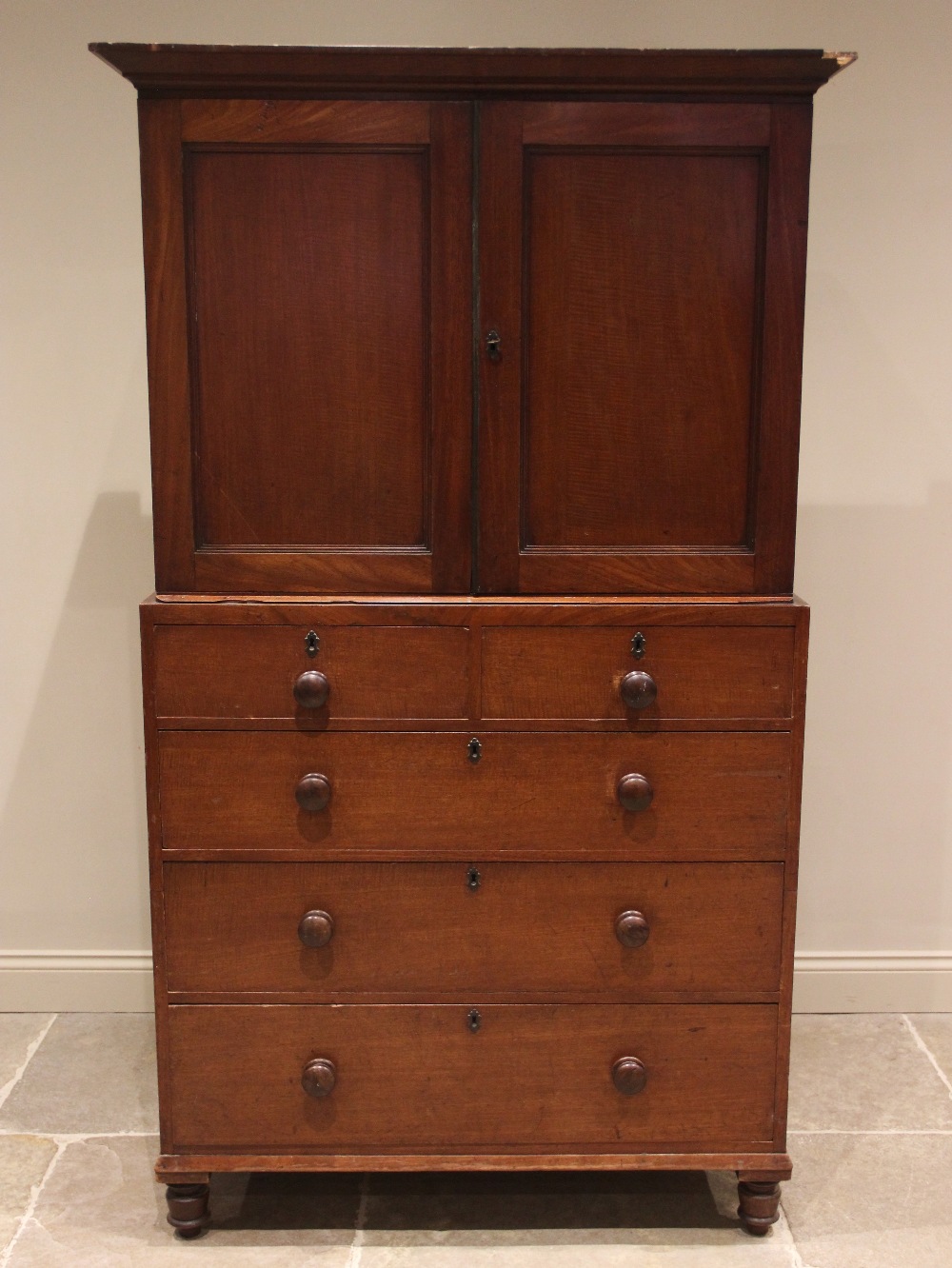 A walnut linen press, 19th century, the cavetto cornice over a pair of panelled doors opening to