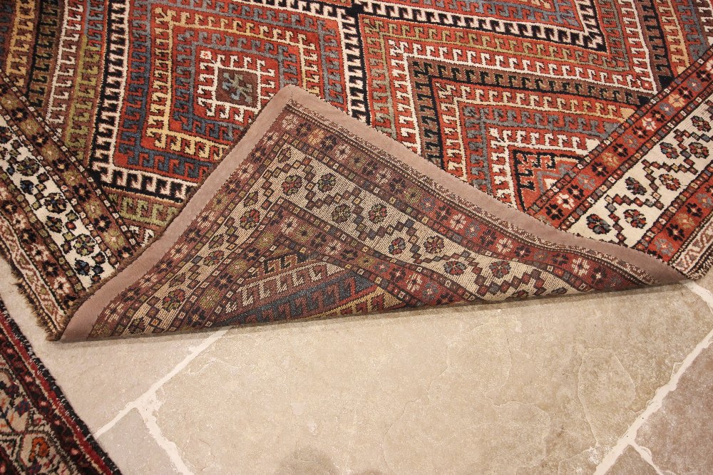 A Caucasian hand knotted wool carpet, in brown, blue, black and white colourways, the central - Image 2 of 3