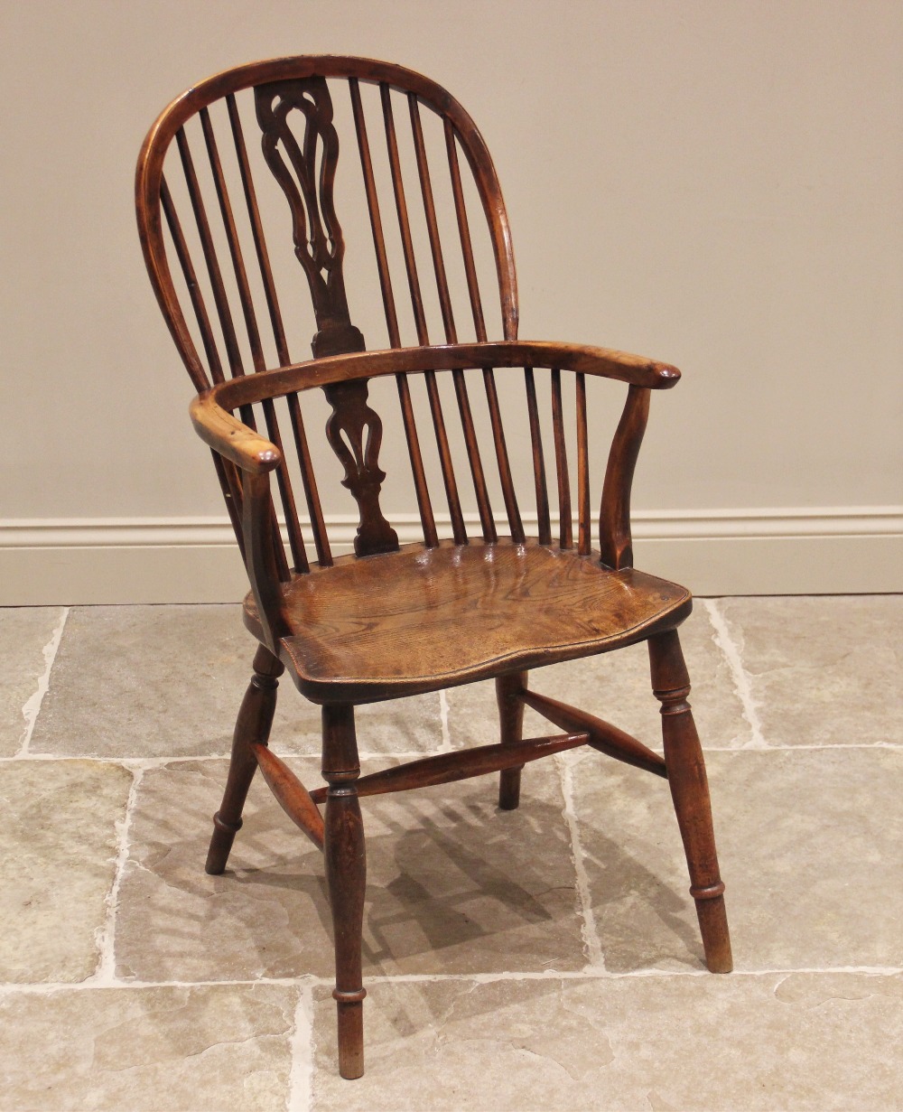 A 19th century yew and elm Windsor elbow chair, the hoop back with central pierced splat above the