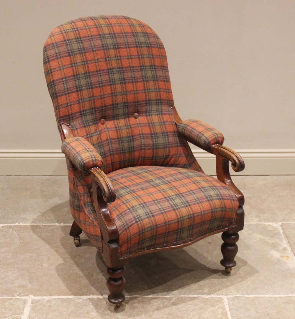 A Victorian mahogany open armchair, later upholstered in tartan fabric, the arched back extending to