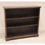 An Edwardian oak open bookcase, the rectangular moulded top upon fluted uprights enclosing the two