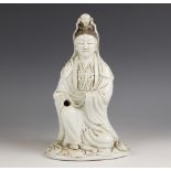 A Chinese Blanc de chine porcelain figure of Guanyin, 19th century, modelled kneeling and wearing