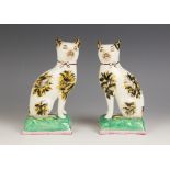 A pair of Staffordshire pottery cats, late 19th century, each with tortoiseshell markings, gilt