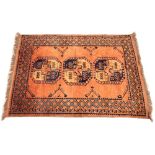 A Turkish wool rug, the three canted square medallions upon a copper coloured ground, within a