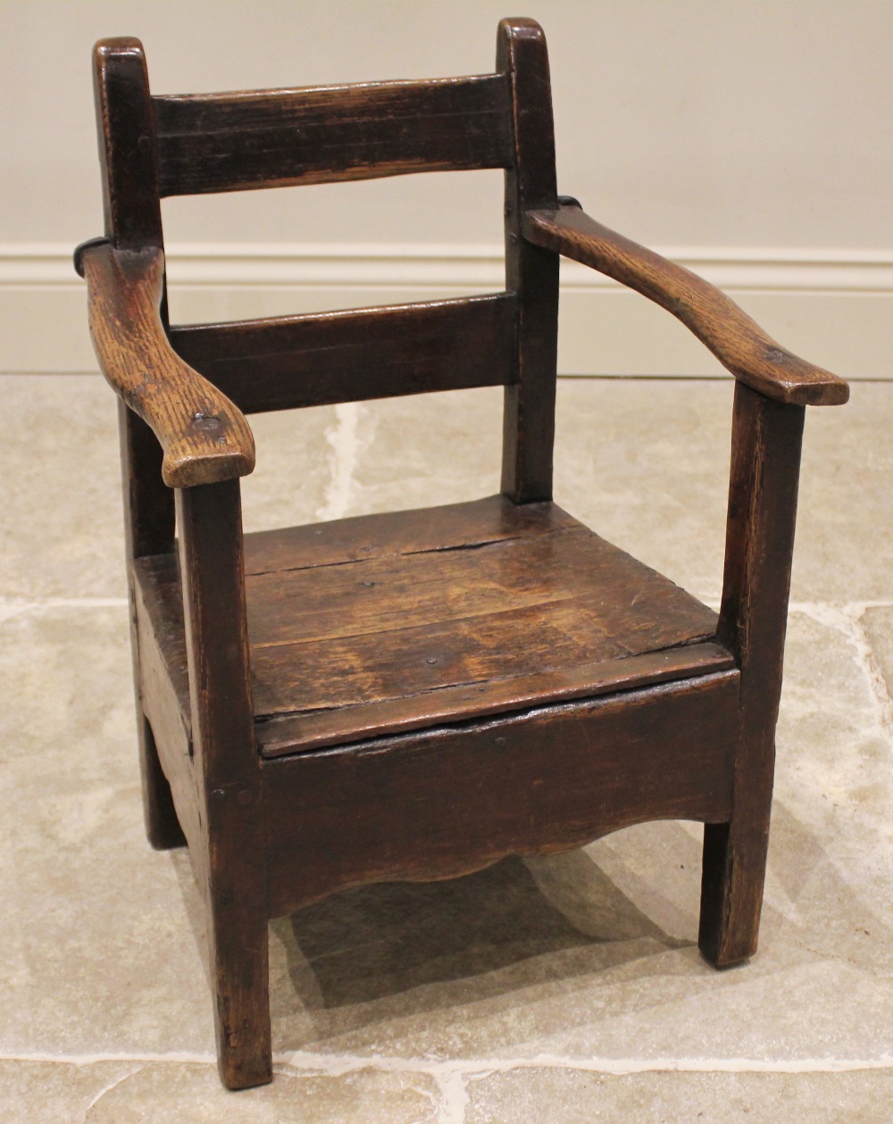 A Welsh oak child's primitive chair, late 18th/early 19th century, the rail back above open arms and