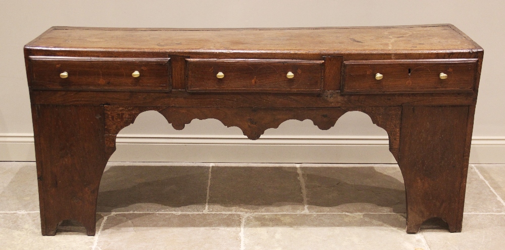 An elm and oak dresser base/work bench, 18th century and later, the plank top over three frieze
