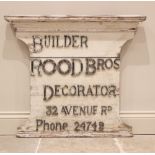 A painted wood builders sign, early/mid 20th century, the shaped white board with a moulded pediment