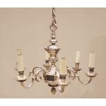 A white metal six branch chandelier, the urn shaped column applied with cast cherub masks, extending