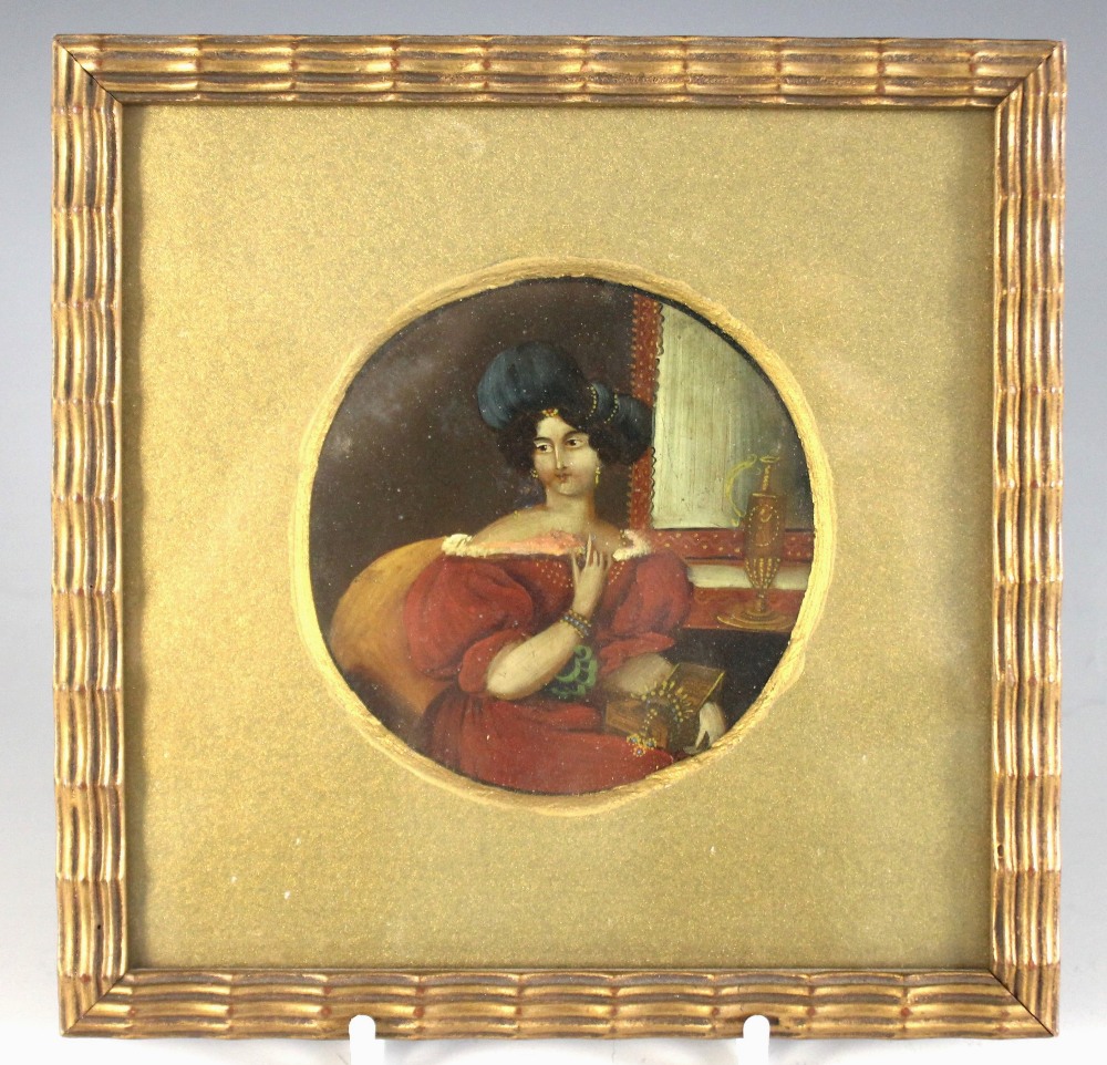 Continental school (19th century), A tondo portrait miniature depicting a lady in a blue hat holding