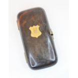 A tortoiseshell and gilt metal mounted cigar case, of rounded oblong form with pique shield with