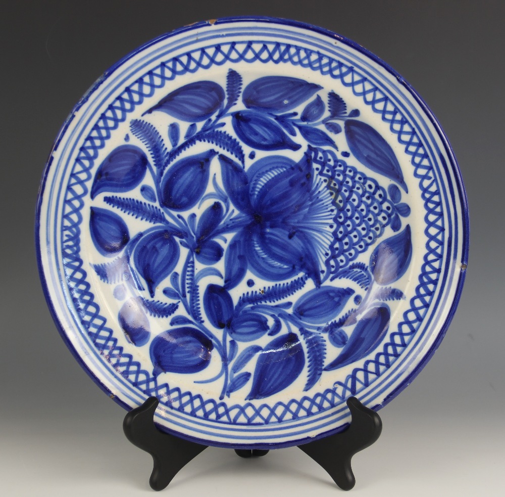 A continental faience tin glazed blue and white charger, late 19th century, painted in underglaze