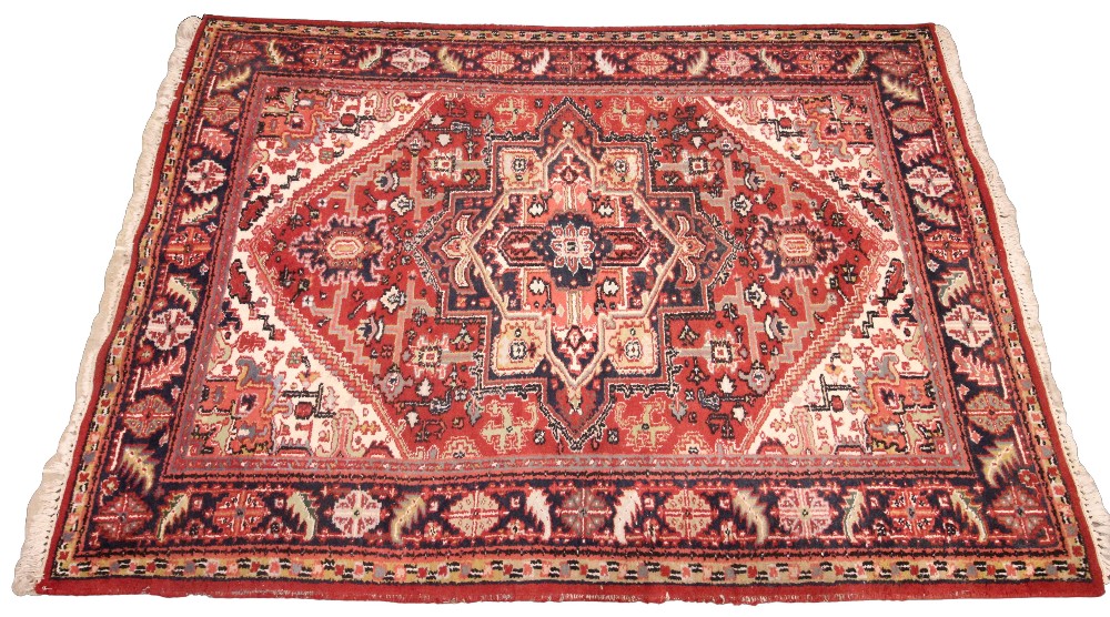 A vintage terracotta ground Persian Heriz rug, north Iran, in red, blue, green and ivory colourways,