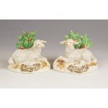 A pair of English porcelain Lambs each with bocage detail, 19th century, each modelled recumbent,