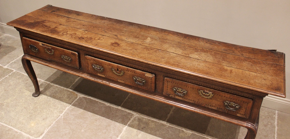 A George III oak dresser base, the rectangular moulded three plank top above three lip moulded - Image 2 of 15