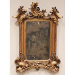 A Rococo style giltwood and composite wall mirror, 20th century, with a moulded 'C' scroll crest and