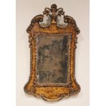 A George II style walnut effect and gilt composite wall mirror, the urn and foliate shaped