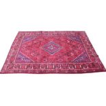 A rich red and blue ground large Persian Joshagan carpet, centred with a diamond shaped medallion on