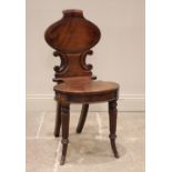 A Regency mahogany hall chair, the oval panel back with moulded 'C' scroll detail over the