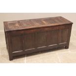 An 18th century oak coffer, the hinged top with five recessed panels opening to a vacant interior,