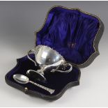 A George V silver cased two handled bowl and spoon, Finnigans Ltd, Dublin 1912, the bowl with cast