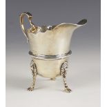 A George V silver cream jug, Wakely & Wheeler, Dublin 1912, in Georgian style, with scroll handle