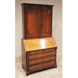 A George III oak and mahogany cross banded bureau bookcase, the associated bookcase with a moulded