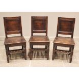 A trio of oak panel back stools/chairs, early 18th century, each with a recessed panel back over a