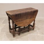 An 18th century oak drop leaf table, the oval top above a single frieze drawer, upon baluster,