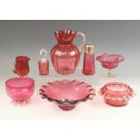 Eight pieces of Victorian and later cranberry glass, comprising: a water jug of lobed baluster form,