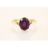 An amethyst and diamond three stone ring, the central oval cut amethyst (estimated 2 carats) with