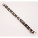 A diamond and sapphire panel bracelet, designed as a continuation of four rows of round cut