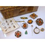 A selection of costume jewellery, to include five silver coloured Scottish brooches, set with orange