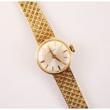 A 9ct gold ladies Garrard wristwatch, the circular cream coloured dial with Arabic numeral and baton