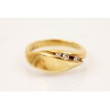 A three stone diamond and 18ct yellow gold ring, the head of the ring designed as moulded leaf shape