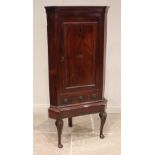 A George III mahogany freestanding corner cupboard, the moulded cornice above a single straight