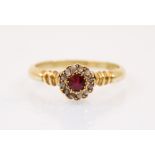 An Edwardian ruby and diamond ring, the central round cut ruby surrounded by a border of diamond