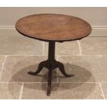 A George III oak tripod table, the circular top upon a plain cylindrical pedestal extending to three
