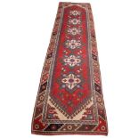 A Turkish wool runner, in red, blue and ivory colourways, the six lozenge shaped medallions upon a