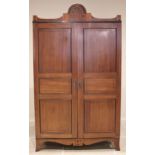 A late George III mahogany wardrobe, possibly Channel Islands, the arched cornice inlaid with