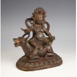 A South East Asian bronze group, 19th century, modelled as a deity atop a cow, with gilt and red